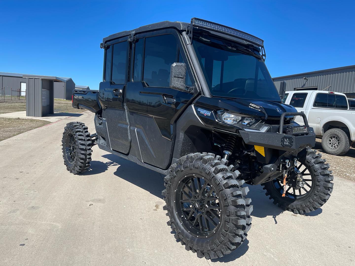 Black Can-Am Defender UTV with custom aftermarket wheels and aggressive off-road tires