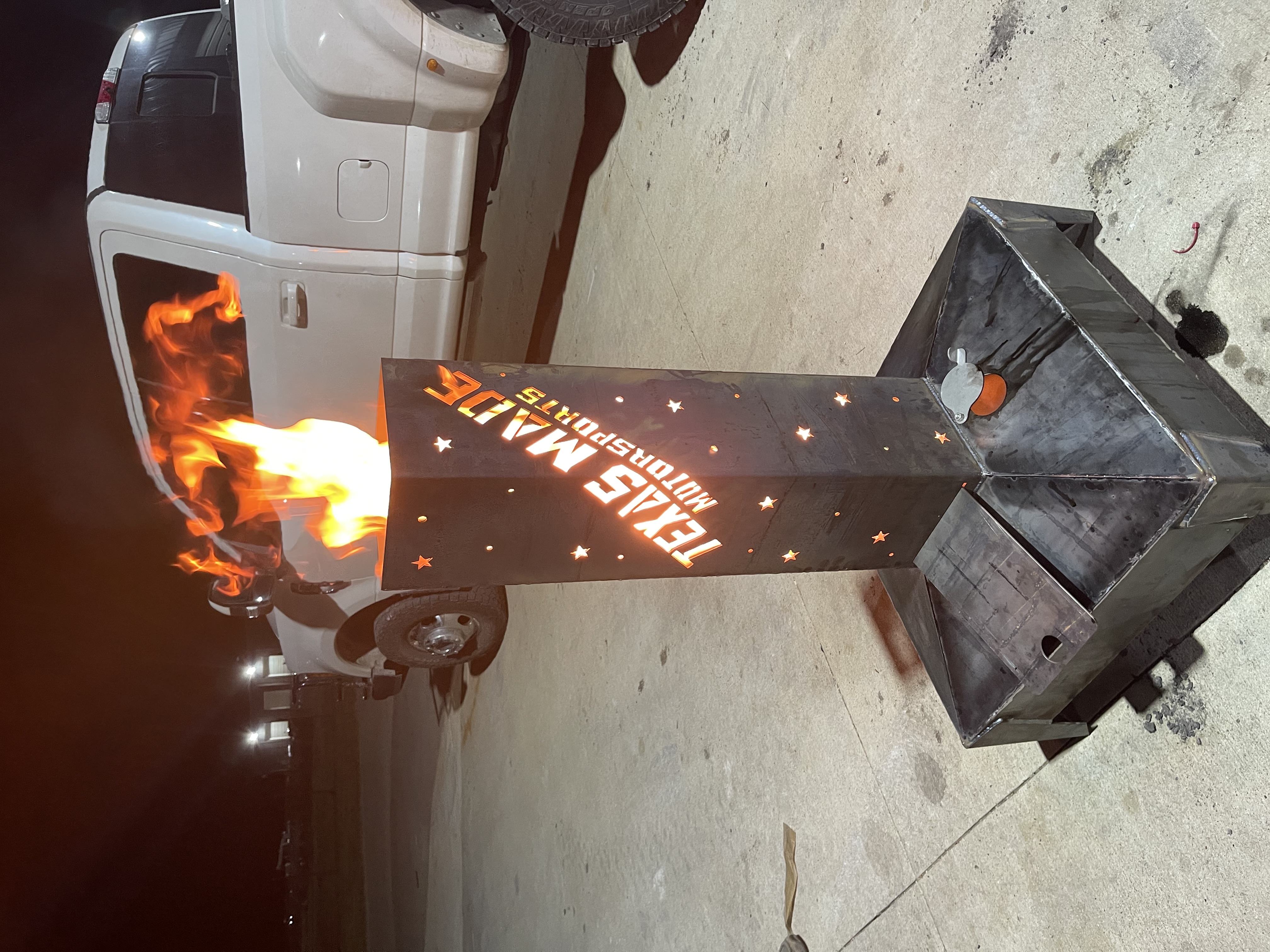 Custom Texas Made Motorsports fire pit with logo cutout and flames