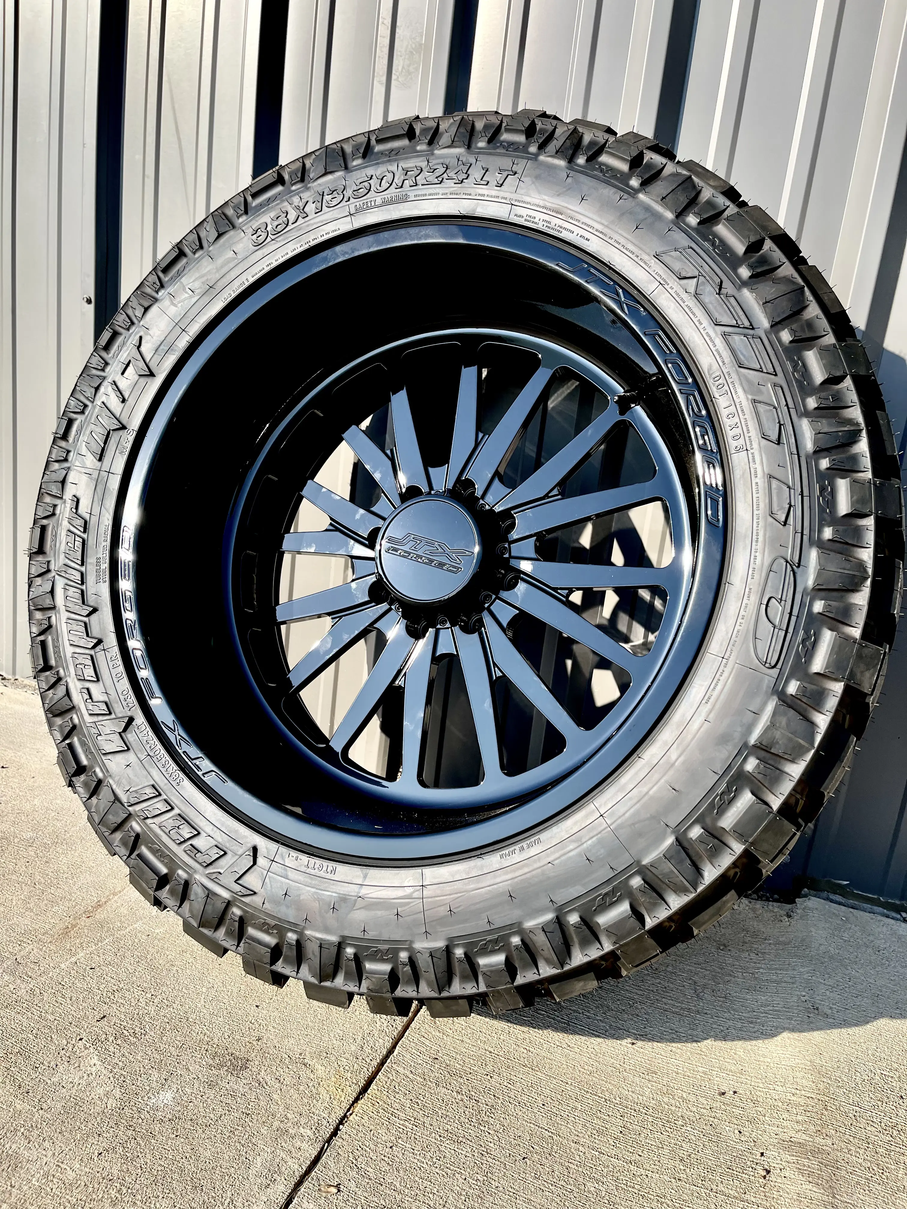 Nitto Ridge Grappler all-terrain tire on black multi-spoke wheel